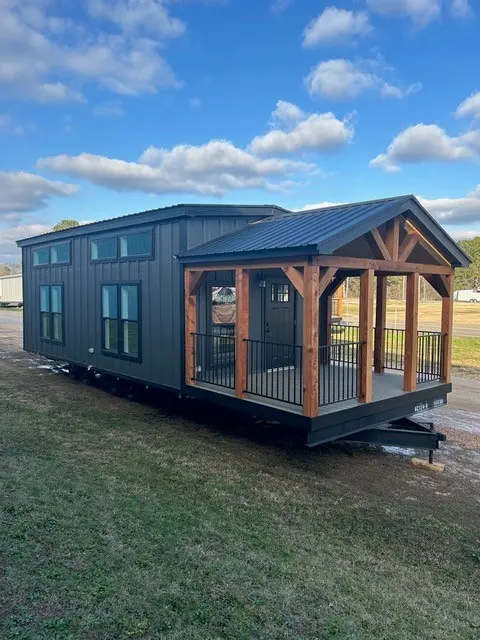 Dark-sided AC-124 cabin with a covered porch and metal roof