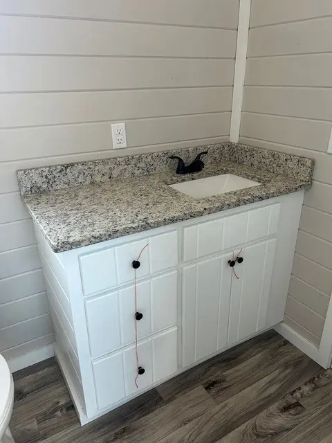 Bathroom vanity with white cabinet and granite top