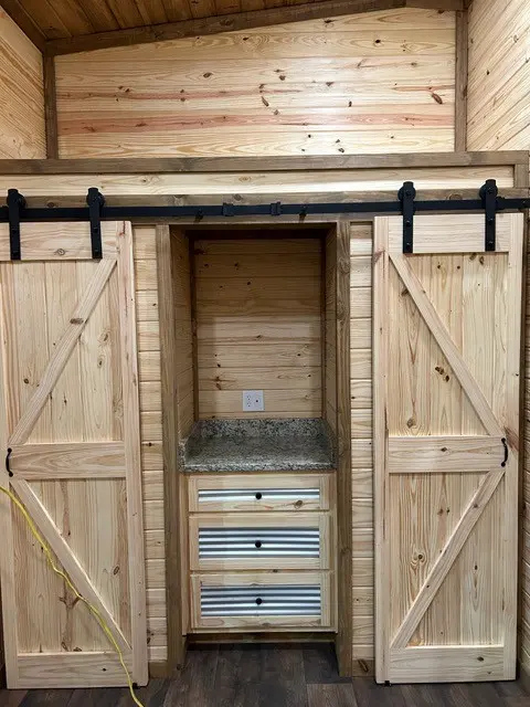 Pine sliding barn doors opening to a storage nook