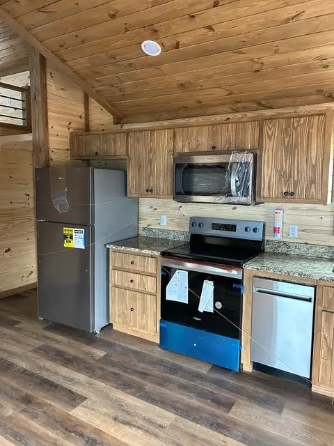 Pine kitchen with stainless steel refrigerator and range